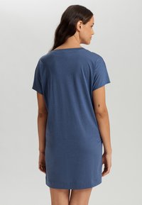 Lyhythihainen mekko tummansinisestä, pehmeästä kankaasta. Ominaisuuksiin kuuluu rento leikkaus ja pyöreä pääntie, jonka pituus on polven ylle.