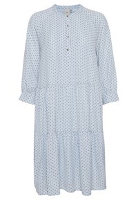 Robe bleu clair jusqu'aux genoux avec des pois noirs, manches longues bouffantes, encolure ronde et trois boutons sur le devant.