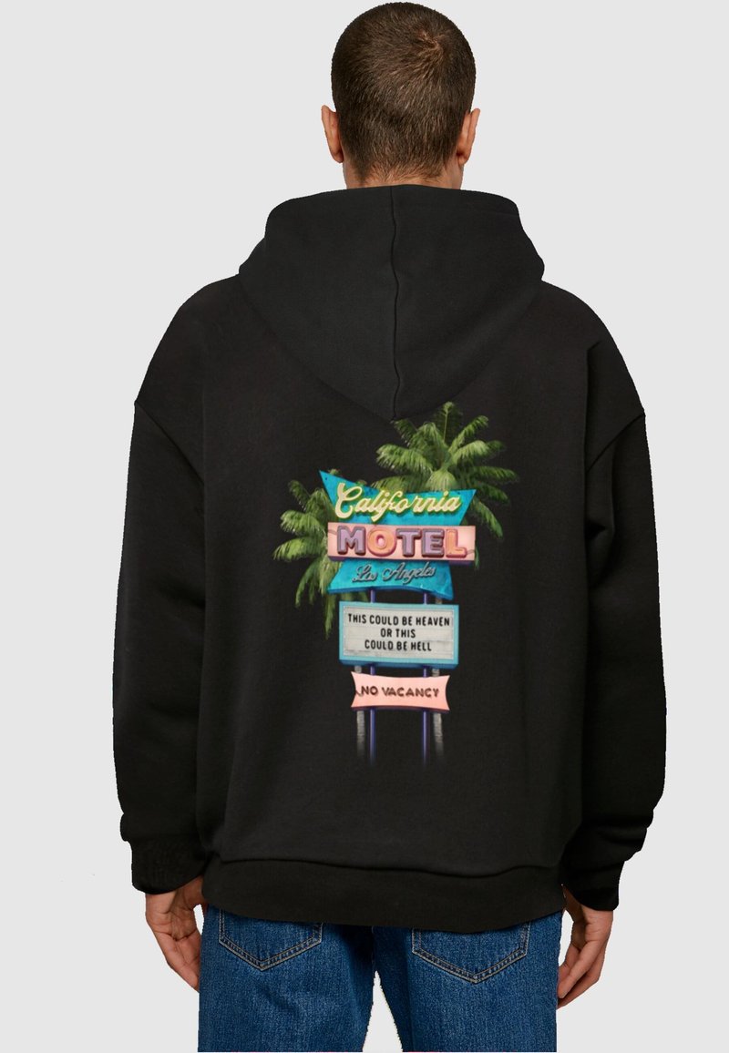 Fekete kapucnis pulóver, élénk motel táblával és pálmafákkal. A felirat: "California Motel, Los Angeles" és "Nincs szabad szoba."