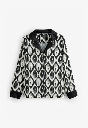 Chemise noire et blanche avec un motif abstrait de main et de cœur. Elle possède un col noir et une fermeture à boutons, fabriquée en tissu lisse.