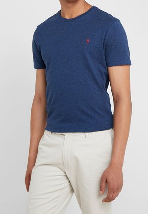 Navy blauwe T-shirt met korte mouwen, gemaakt van zachte katoen, met een ronde hals en een klein rood logo op de borst. Combineer met lichte broek.