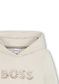 Felpa beige con una grande grafica "BOSS" in rilievo di colore marrone chiaro. Presenta un cappuccio con cordini e una morbida fodera interna.