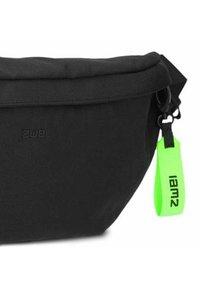 Bolso de tela negra con forma redondeada, que cuenta con una solapa en la parte superior y un tirador de cremallera de neón verde con "Iam2" impreso en él. Diseño minimalista.