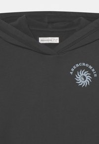 Felpa nera con cappuccio caratterizzata da una grafica di un sole azzurro chiaro con il testo "ABERCROMBIE", texture morbida, tasca a marsupio e cappuccio regolabile con coulisse.
