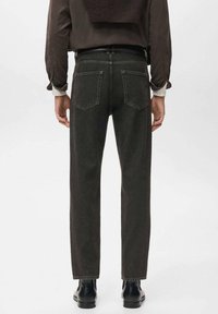 Jeans de mezclilla gris oscuro con corte recto, que cuentan con dos bolsillos traseros y un sutil detalle de costura. Llevado con un suéter marrón.