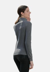 Pull gris en tricot avec col montant et motif en losange. Le matériau présente une texture lisse, un design ajusté, ainsi qu'un ourlet et des poignets côtelés.