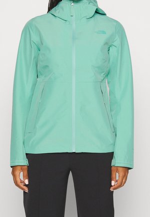 Giacca impermeabile leggera di colore verde menta con cappuccio, chiusura con zip e tasche laterali, caratterizzata da una texture liscia e un branding minimal.