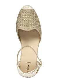 Zapato de tela tejido beige con punta redondeada, tapa blanca en la puntera y correa en el tobillo. Forro interior suave. Logo de Geox visible en la suela.
