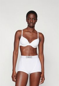 Fehér melltartó állítható pántokkal, varrás nélküli kosarakkal, magas derekú fehér alsóneművel, amelynek márkás elasztikus derékpántja van.