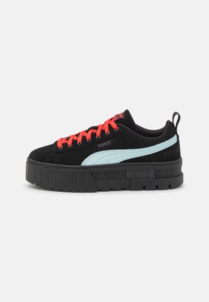 Sorte ruskind platform sneakers med lyseblå sidelogo og klare røde snørebånd. Har en tyk sort sål og kontrasterende logodetalje.