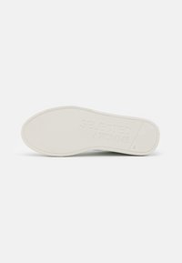 Sohle des weißen Sneakers mit strukturiertem Grip, eingeprägtem Markennamen "SELECTED HOMME" und der Größe "41" im Fersenbereich.