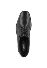 Scarpa elegante in pelle nera con finitura liscia, punta arrotondata e design con lacci. L'interno presenta un marchio stampato sulla soletta.
