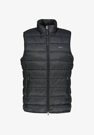 Colete acolchoado preto com gola alta, fecho frontal com zípper, e dois bolsos laterais. Apresenta textura acolchoada e detalhe do logótipo no peito.