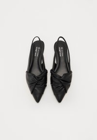 Črne usnjene slingback pete z ostrim nosom, ki imajo na sprednji strani vozlate detajle in gladko teksturo.
