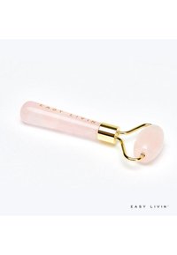 Rouleau facial en quartz rose avec un cadre en métal doré, doté d'une tête lisse et arrondie et d'un long manche gravé de "EASY LIVIN'".