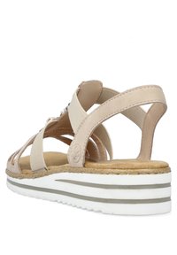 Sandali beige con cinturini elastici, soletta in pelle marrone imbottita e suola esterna bianca con righe grigie. Design con apertura sul retro.