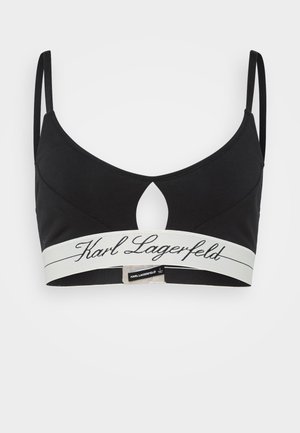 Bralette nera con spalline sottili, un'apertura a chiave e un elastico bianco con il logo "Karl Lagerfeld" stampato in nero. Tessuto morbido.