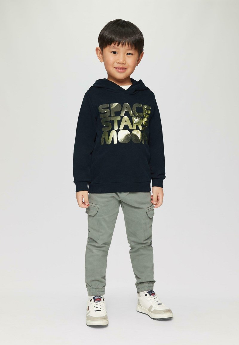 Navy hoodie met metallic gouden tekst "SPACE STARS MOON," gecombineerd met lichtgrijze cargobroek en witte hoge sneakers.