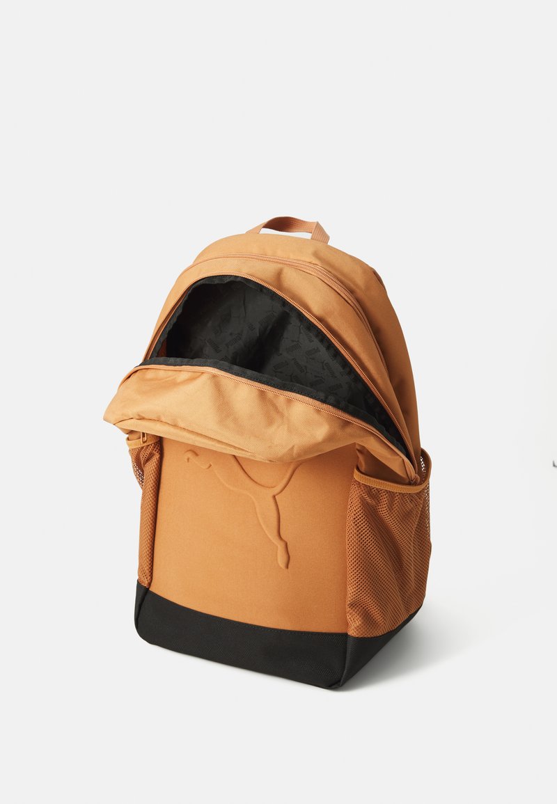 Mochila naranja con fondo negro, bolsillos laterales de malla y un interior con patrones. Cuenta con un gran compartimento principal y un asa en la parte superior.
