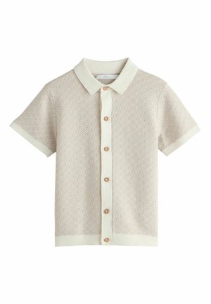 Short-sleeve, light beige polo shirt with a textured pattern, cream collar and cuffs, and rose gold buttons down the front.