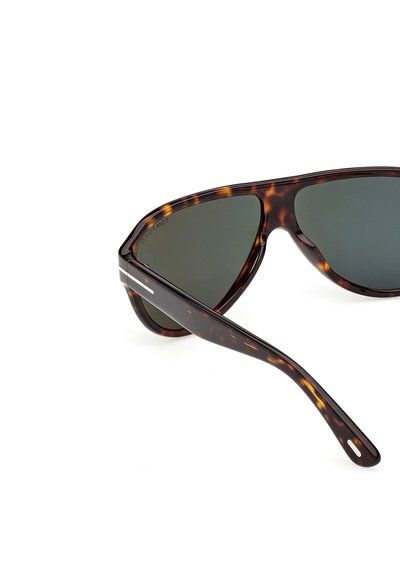 Lunettes de soleil à motif écaille avec verres foncés, vues en perspective latérale sur fond blanc.