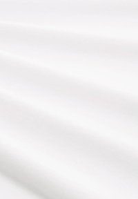 Glatter weißer Stoff mit sanften Falten, die zarte Schatten und eine saubere, minimalistische Textur über der Oberfläche erzeugen.