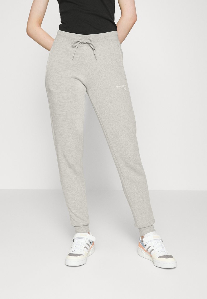 Pantalones de chándal de color gris claro, hechos de una tela suave, con una cinturilla elástica, cordón ajustable y tobillos ajustados; presenta un detalle de logo blanco.