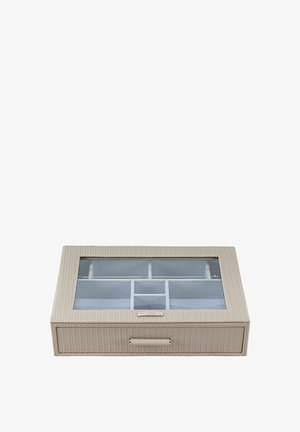 Organisateur de bijoux avec texture tissée beige, couvercle transparent, plusieurs compartiments et un tiroir coulissant à l'avant.