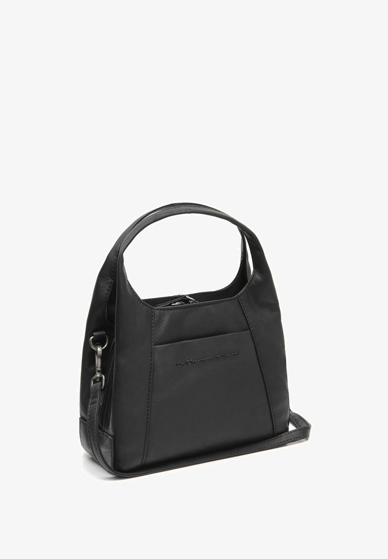 Musta nahkainen käsilaukku yläkahvalla, vetoketjukiinnityksellä, etutaskulla ja irrotettavalla olkahihnalla valkoista taustaa vasten.