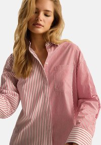 Czerwona i biała w paski koszula zapinana na guziki, wykonana z bawełny, z długimi rękawami, kieszenią na piersi oraz luźnym krojem z klasycznym kołnierzykiem.