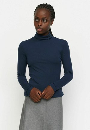 Marineblauwe turtleneck met lange mouwen in ribstof, aansluitend ontwerp met een soepele textuur, gecombineerd met een grijze rok.