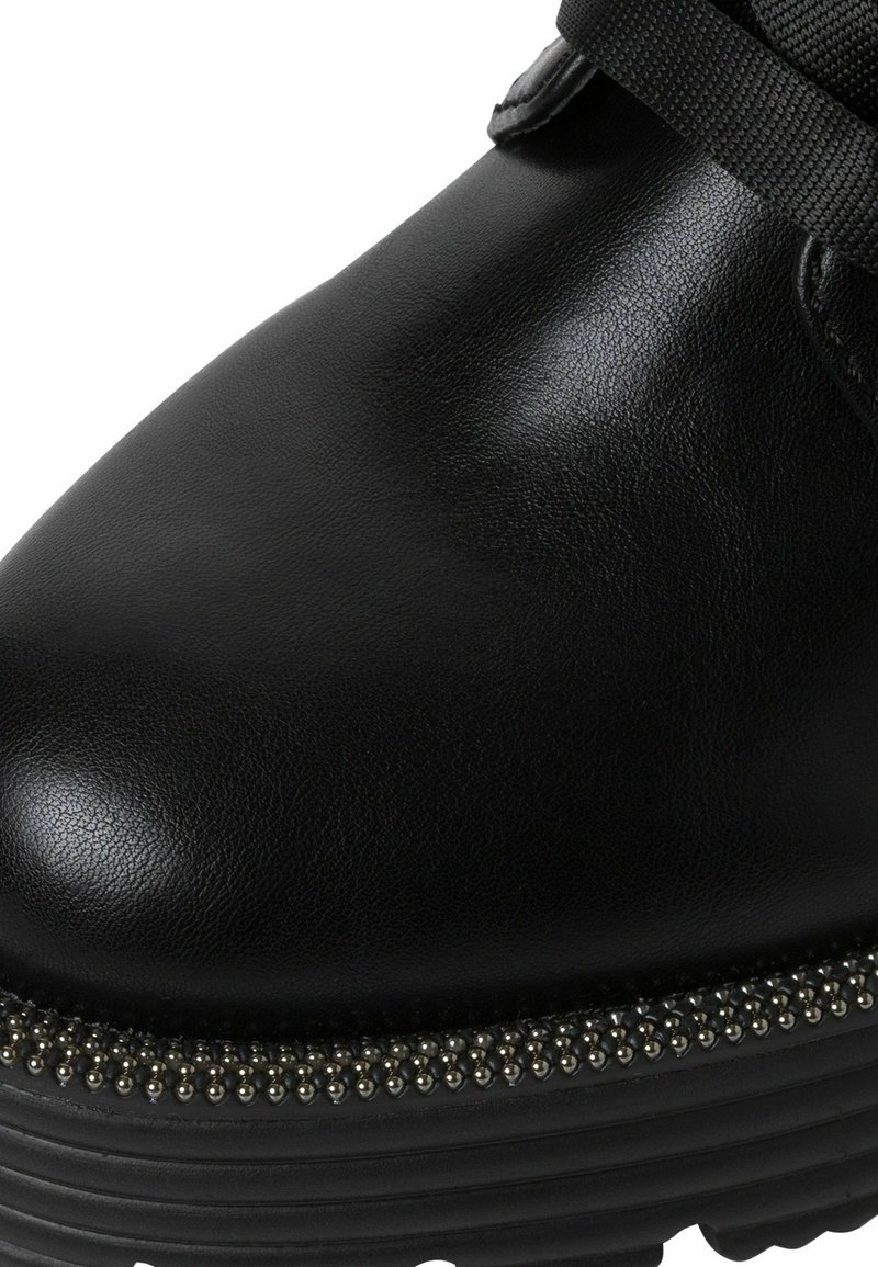 Stivale alla caviglia in pelle nera con una superficie liscia, un bordo decorativo di perline e una suola spessa e scolpita per un maggiore supporto.