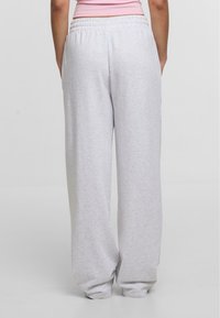 Lys grå sweatpants med elastisk talje, sidelommer og tapered cuffs. Fremstillet af blødt, tekstureret stof.