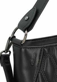 Bolso de mano de cuero negro con un patrón hexagonal texturizado, con detalles en hardware plateado y una correa desmontable. Acabado suave.
