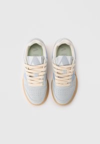 Lys grå mockasko med blå detaljer, beige snøring, perforert tåboks og brun gummisåle. Toppvinkel med minimalistisk design.