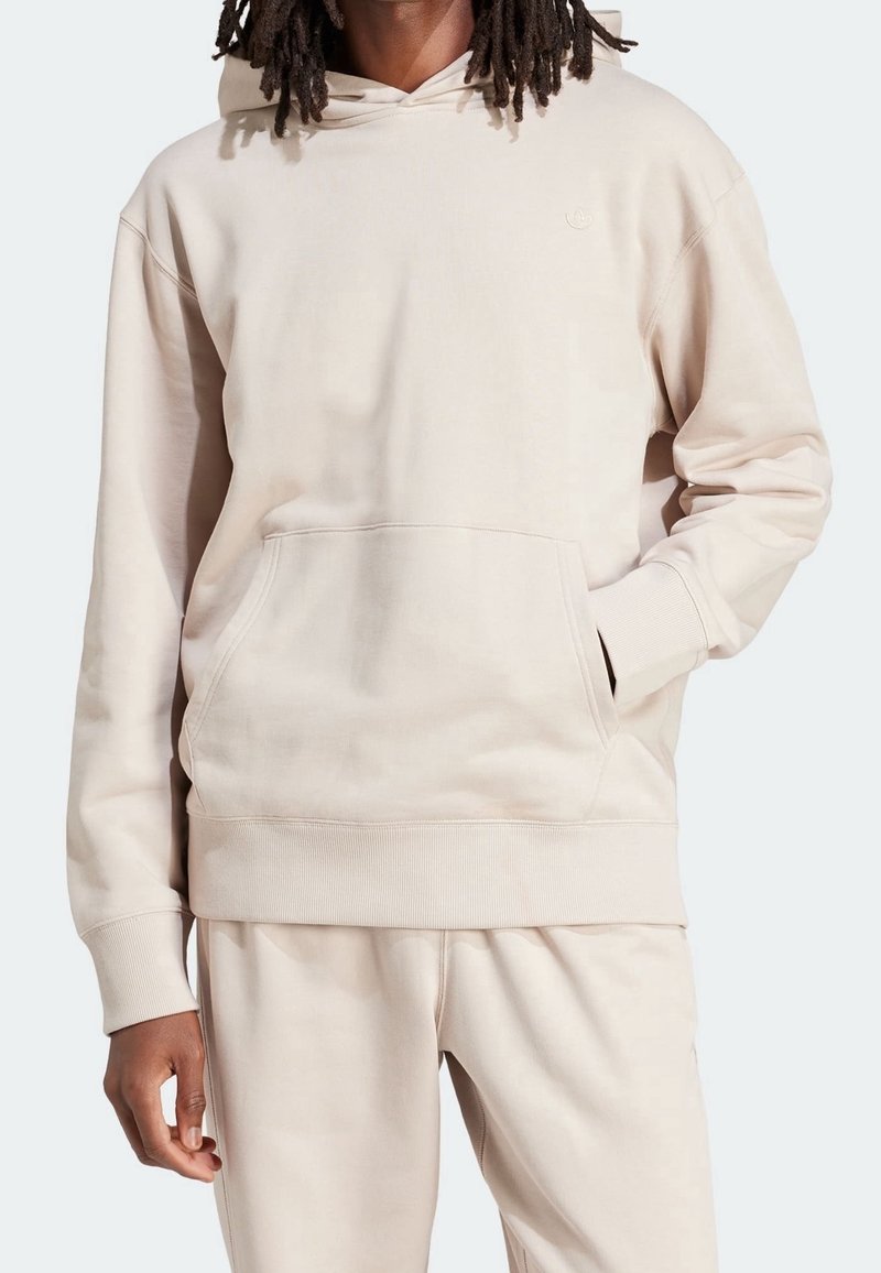 Beige hoodie made of soft fabric, featuring a front pocket, ribbed cuffs, and a drawstring hood. Smooth texture with minimal branding.