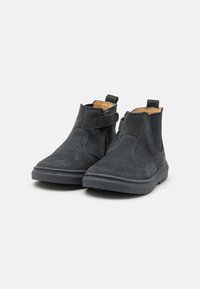 Botines de ante negra con suela de goma, que presentan un cierre de cremallera, paneles laterales elásticos y una superficie texturizada.