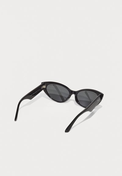 Black cat-eye sunglasses with dark lenses. Glossy plastic frame, tapered arms, and subtle branding on the inner side of the temple.