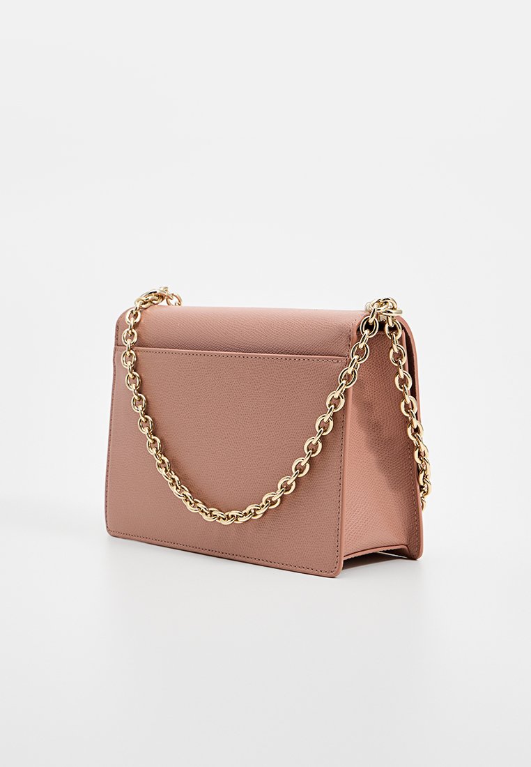 Rechteckige, staubige rosa Lederhandtasche mit strukturiertem Finish und einer goldenen Kettenriemen, die auf einer weißen Oberfläche steht.