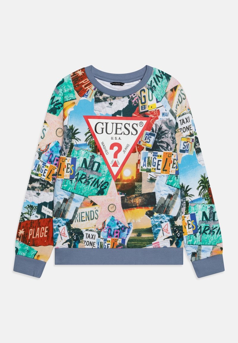 Sweatshirt à manches longues avec un collage multicolore de panneaux de signalisation, de palmiers et de coucher de soleil, présentant un grand logo triangle Guess rouge et blanc.
