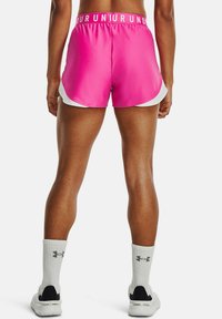 Pantalones cortos de carrera rosa cortos con un borde blanco, que presentan una cintura elástica con logo. Usados con calcetines deportivos blancos y zapatos negros.
