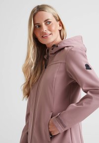 Light pink soft-shell jacket with a hood, featuring a front zipper, side pockets, and black accents on the cuffs and shoulder.