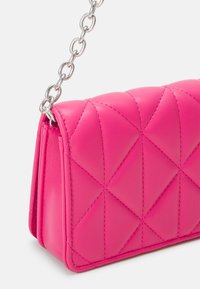 Fuchsia quilted leather handbag with silver chain strap, featuring a geometric pattern and smooth texture, showcasing clean lines and a structured shape.