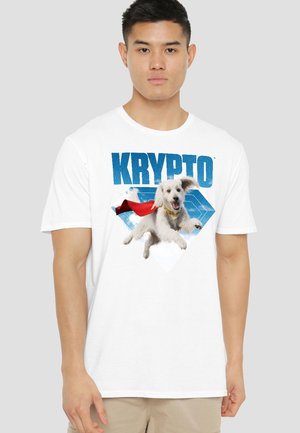 Man wearing white t-shirt with graphic of a flying white dog in a red cape and the word "Krypto" in blue above.