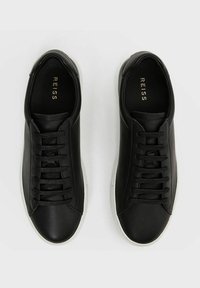 Schwarze Leder-Sneaker mit runder Spitze, sechs Paar Schnürsenkel, minimalistischem Design und weißer Gummisohle. Goldene "REISS"-Marke auf der Innensohle.