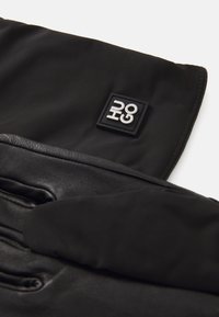 Gants d'hiver noirs avec un contraste de tissu doux et de cuir lisse. Comprend un patch logo brodé et un design élégant et épuré.