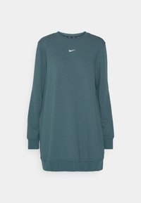 Mikina šaty Nike v tmavě modré barvě, s dlouhými rukávy, kulatým výstřihem a malým bílým logem na hrudi. Měkká texturovaná látka.
