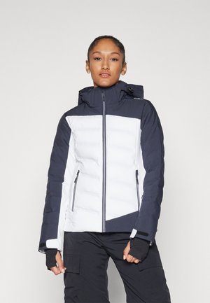 Veste matelassée avec un design bicolore bleu marine et blanc, poches zippées, capuche ajustable et accents noirs sur les poignets.