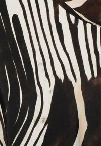 Tessuto bianco e nero caratterizzato da audaci motivi a righe di larghezze variabili su una superficie texture, creando un effetto visivo dinamico.
