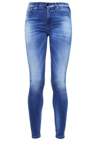 Jeans ajustados en denim azul medio, con un acabado desvaído, diseño de cinco bolsillos y cierre de cremallera con botón.